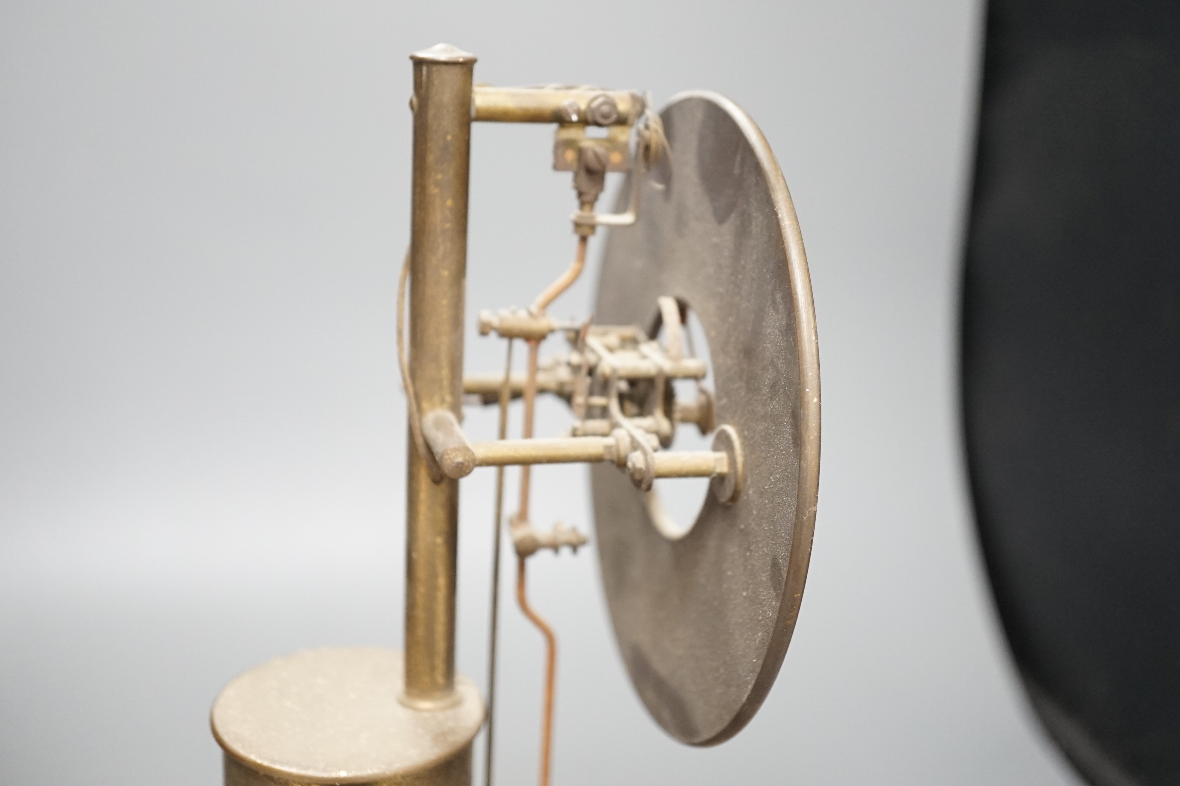A Bulle electric pendulum clock, with large central brass pillar supporting the 14cm. dial, under a glass dome on a mahogany plinth